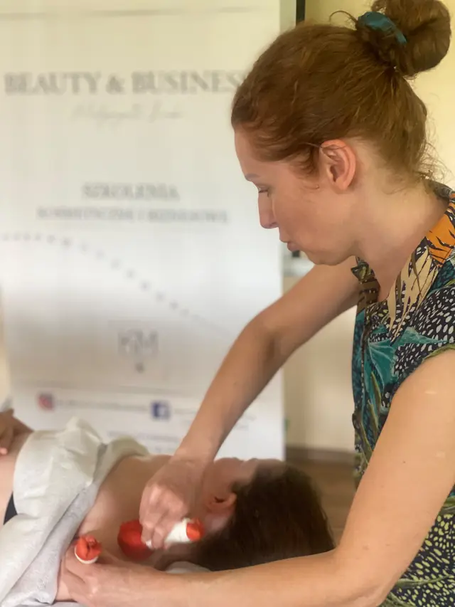 Kursantka ćwiczy masaż szyi jedwabnymi stemplami na szkoleniu z Ajurwedy