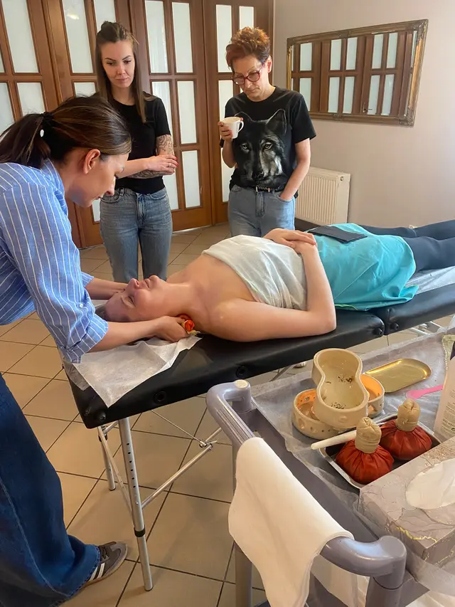 Pokaz rytuału Ajurwedyjskiego na szkoleniu – kursantki obserwują pracę na modelce