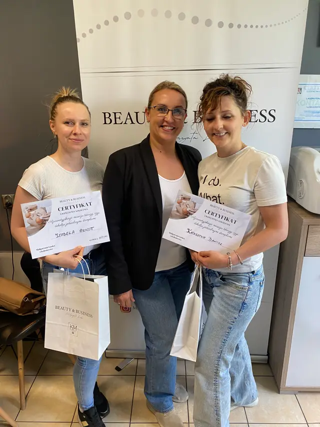 Uczestniczki szkolenia z certyfikatami i prowadząca na tle banera Beauty & Business